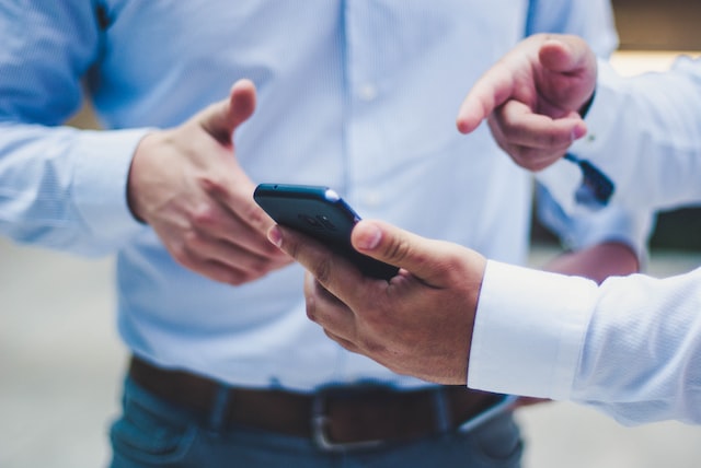 man points to something on phone screen