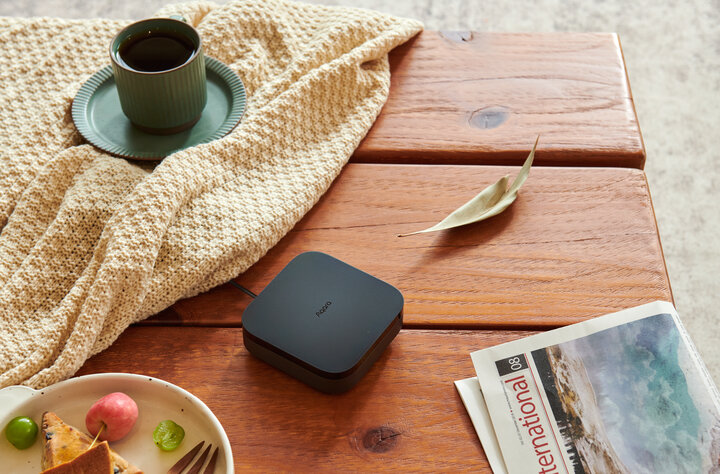 Hub M3 with edge capabilities and Matter support for private, local smart homes on a table with a leaf, tablecloth, plate with food and a mug