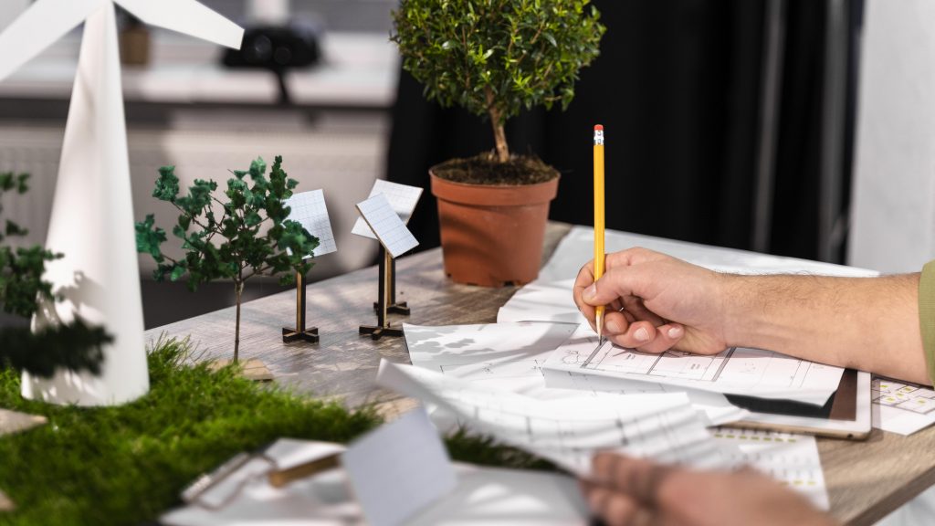 Side view of man working on an eco-friendly wind power project with paper plans